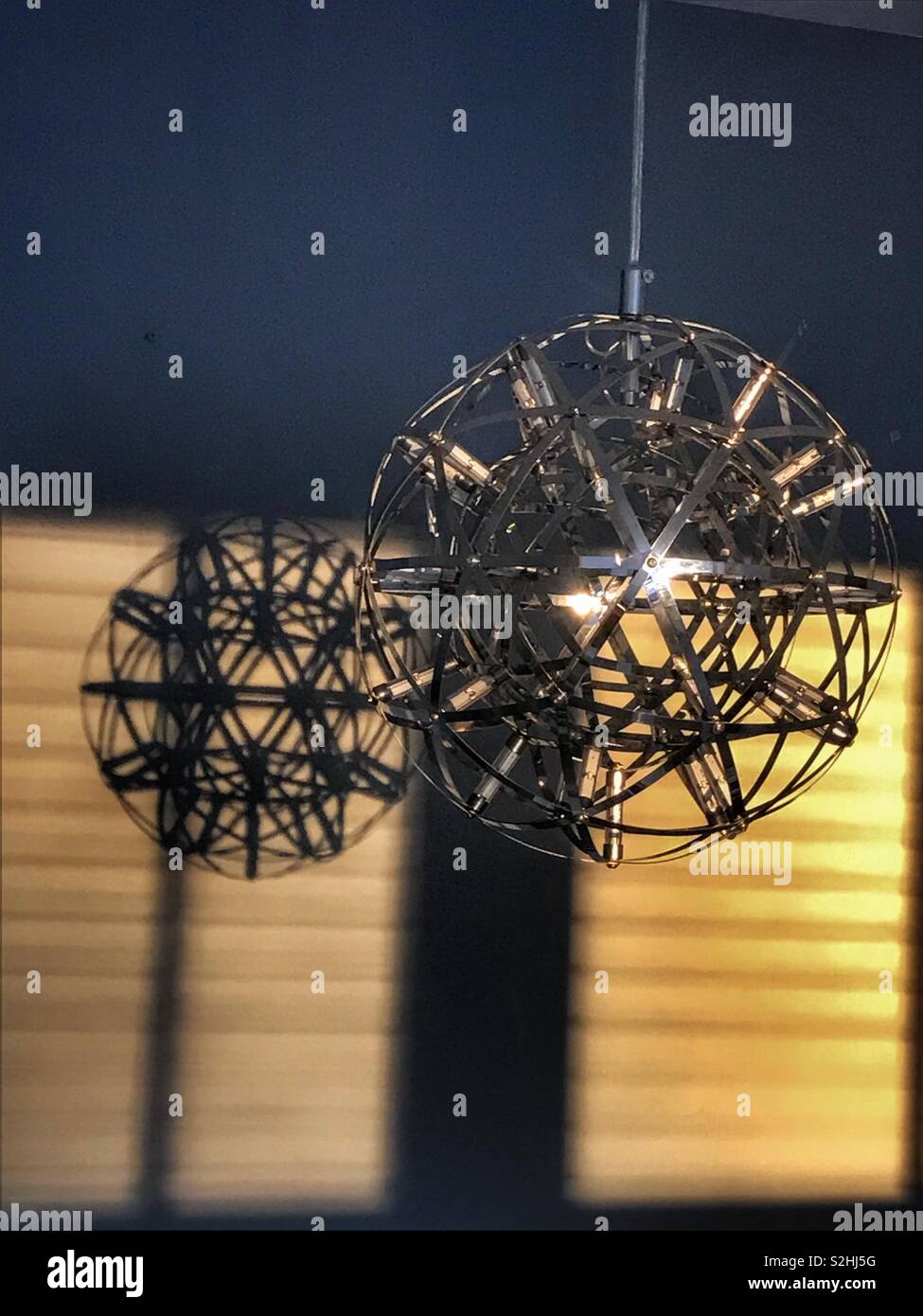 Modern light pendant casting a shadow on a blind Stock Photo Alamy