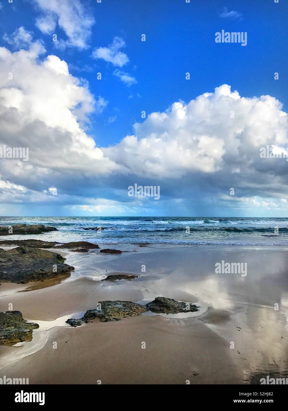 Australia Urunga beach summer ocean Pazifik water sand stone beautiful clouds shadow moment lights blue waves reflections Stock Photo