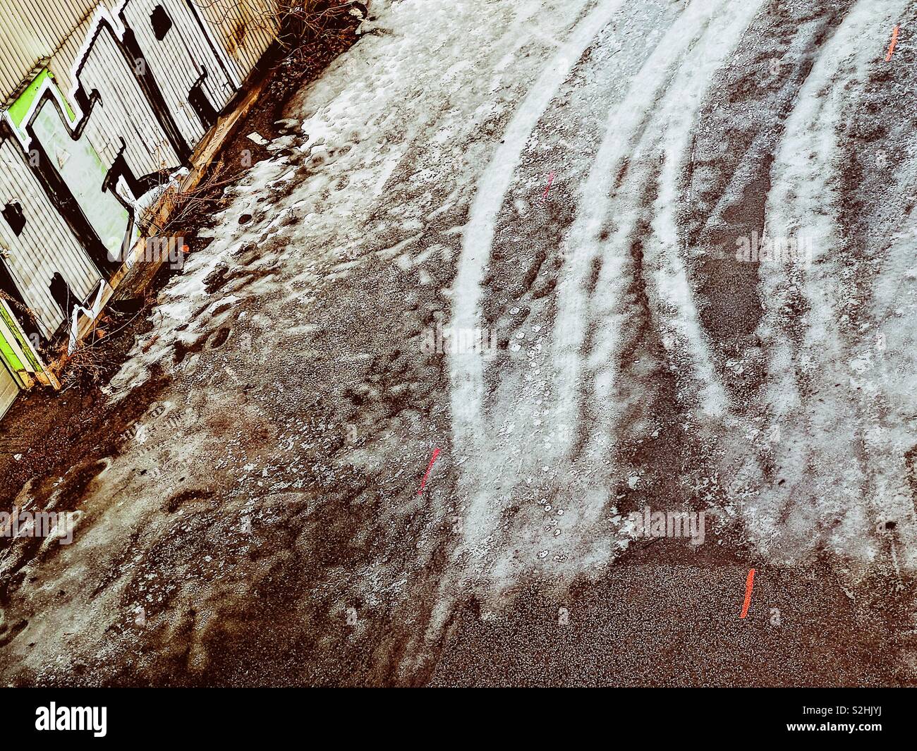 Graffiti next to tyre tracks on icy road - Smartphone Captured Stock Image