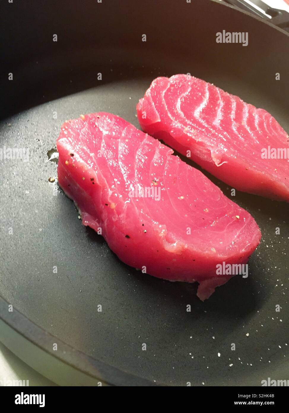 Fresh tuna steaks being seared in a hot skillet - Smartphone Captured Stock Image