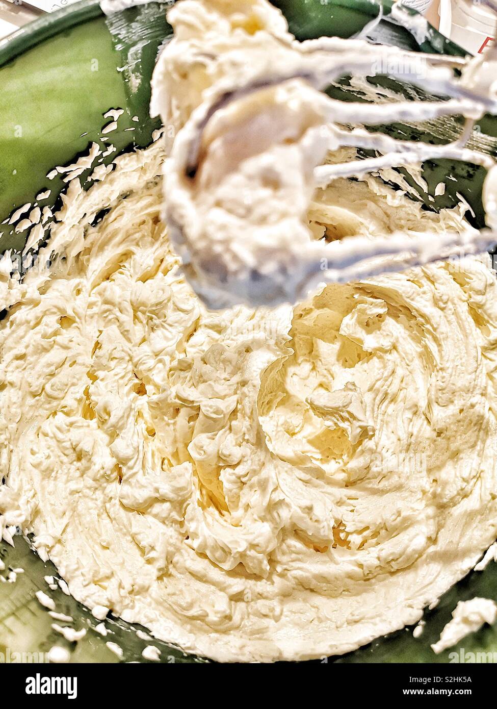 Whisking cream cheese, eggs, caster sugar, vanilla pod and soured cream
