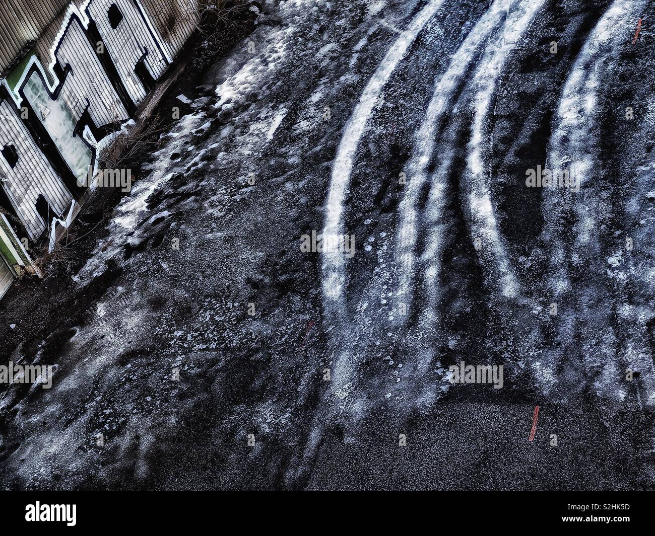Tyre tracks frozen in ice and urban graffiti - Smartphone Captured Stock Image