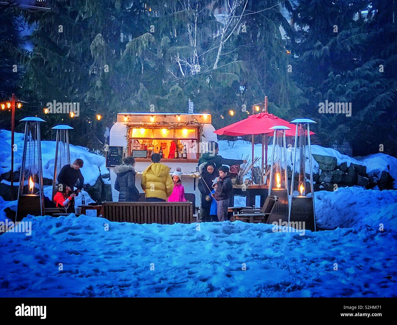 Outside in the snow, outside the Four Seasons Resort, Whistler Canada. Cooking S’mores - Smartphone Captured Stock Image