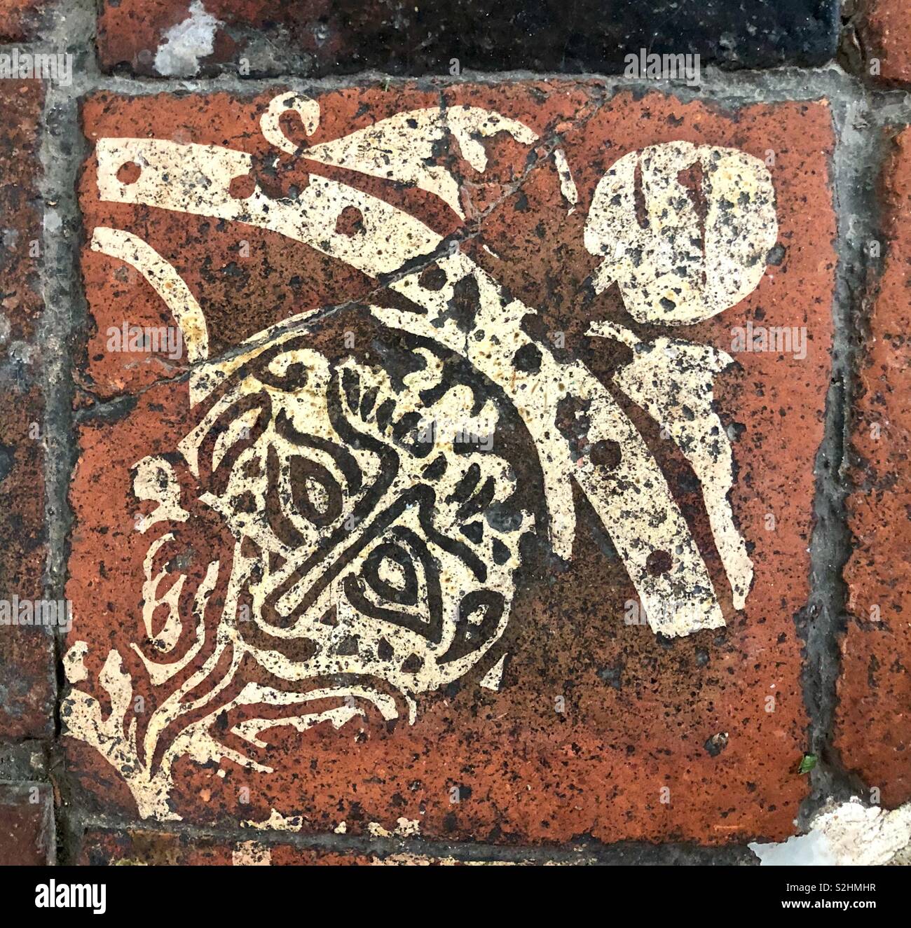 Medieval encaustic heraldic decorative tile, with Lion’s head, Vale of Evesham. - Smartphone Captured Stock Image
