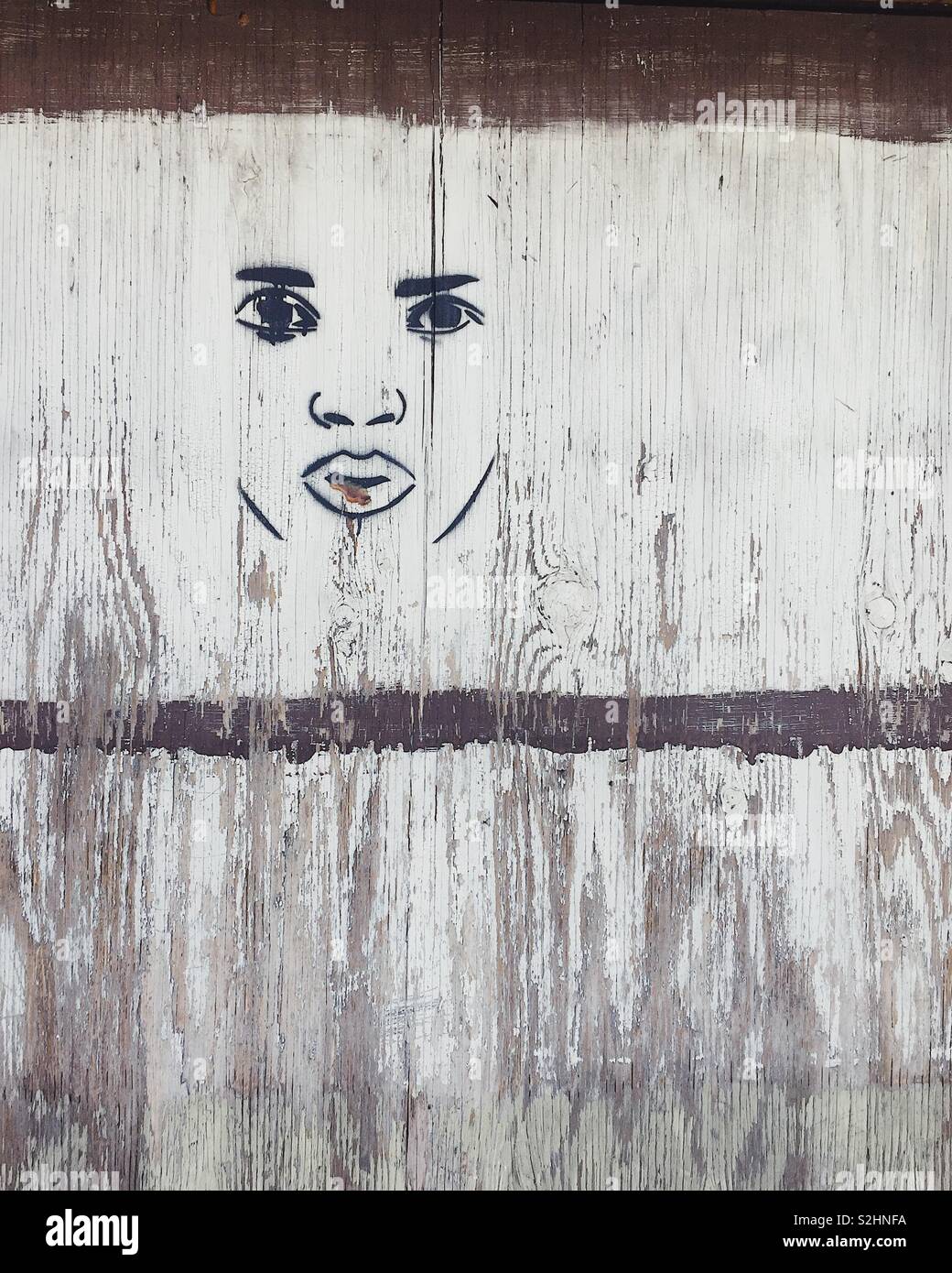 Closeup of face street art on white wood background - Smartphone Captured Stock Image