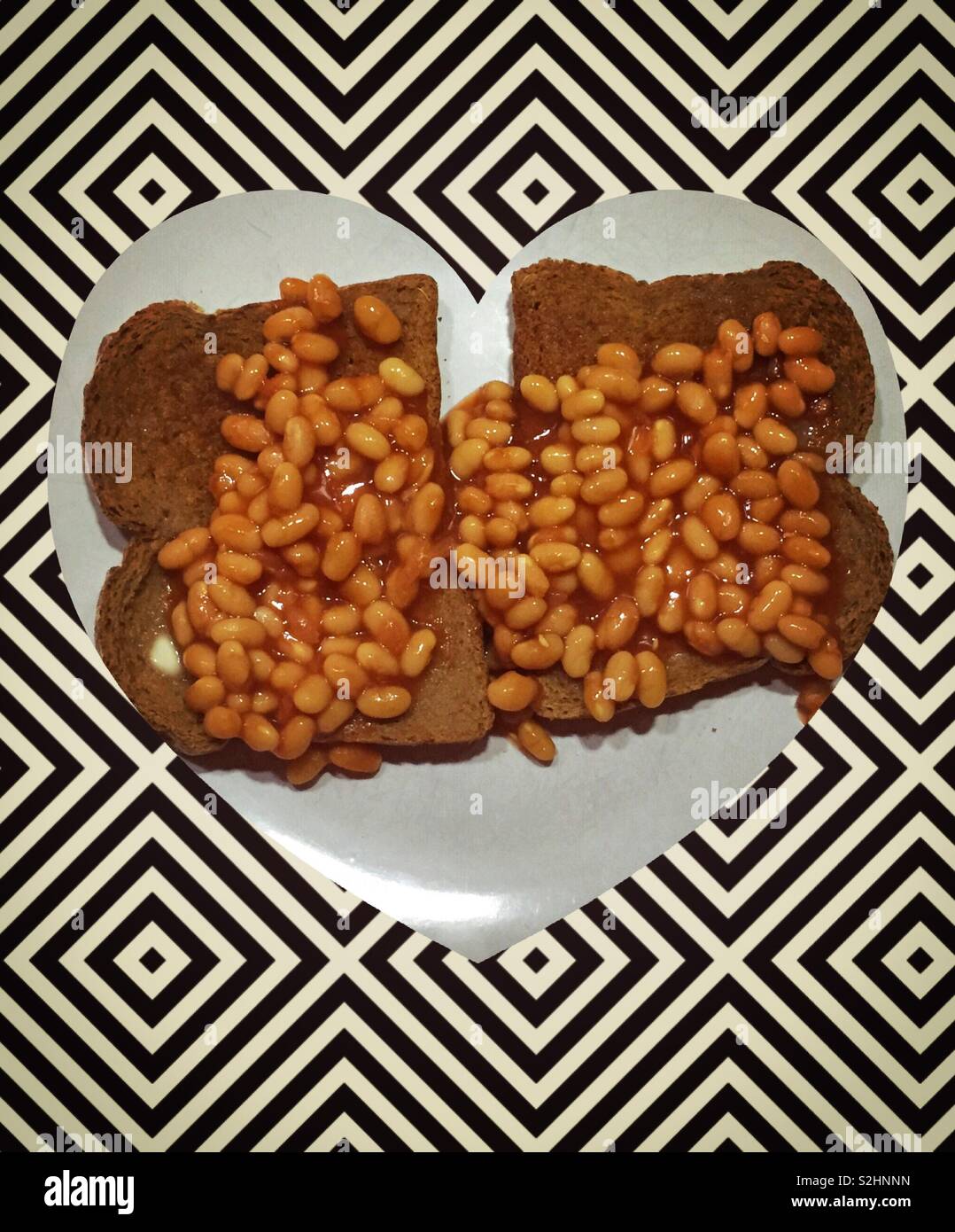 Beans on toast on heart shaped plate.  Healthy nutrition. A nutritional meal - Smartphone Captured Stock Image