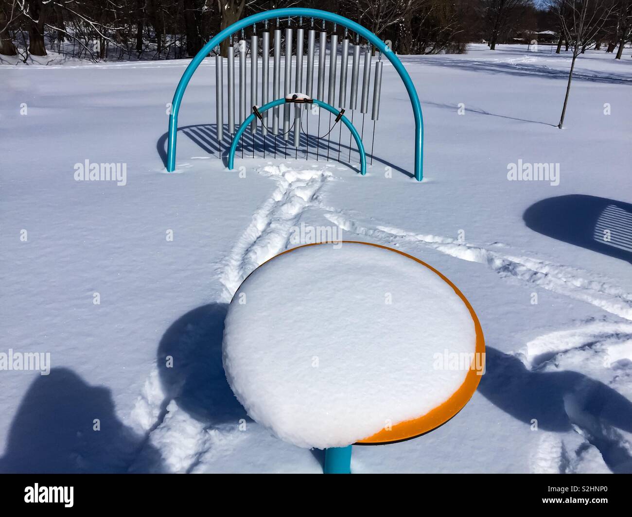 Musical instruments covered in fresh snow. A children’s musical play area in winter, Ontario, Canada. - Smartphone Captured Stock Image