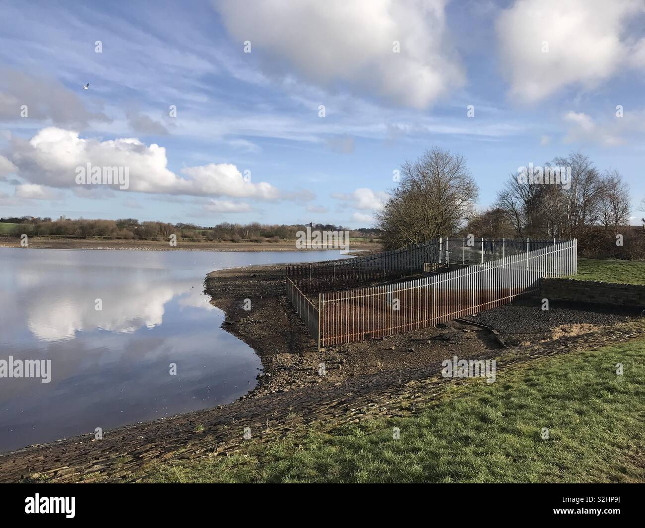 Very low water levels in a holding reservoir in East Ardsley, West Yorkshire, England. The water is usually over the left hand side railings. Stock Photo