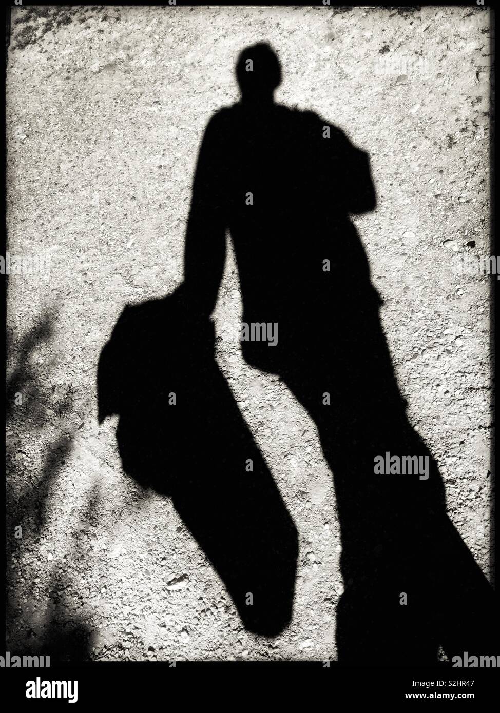 Silhouette of a man carrying a sack of newly delivered grapevines, Catalonia, Spain. - Smartphone Captured Stock Image