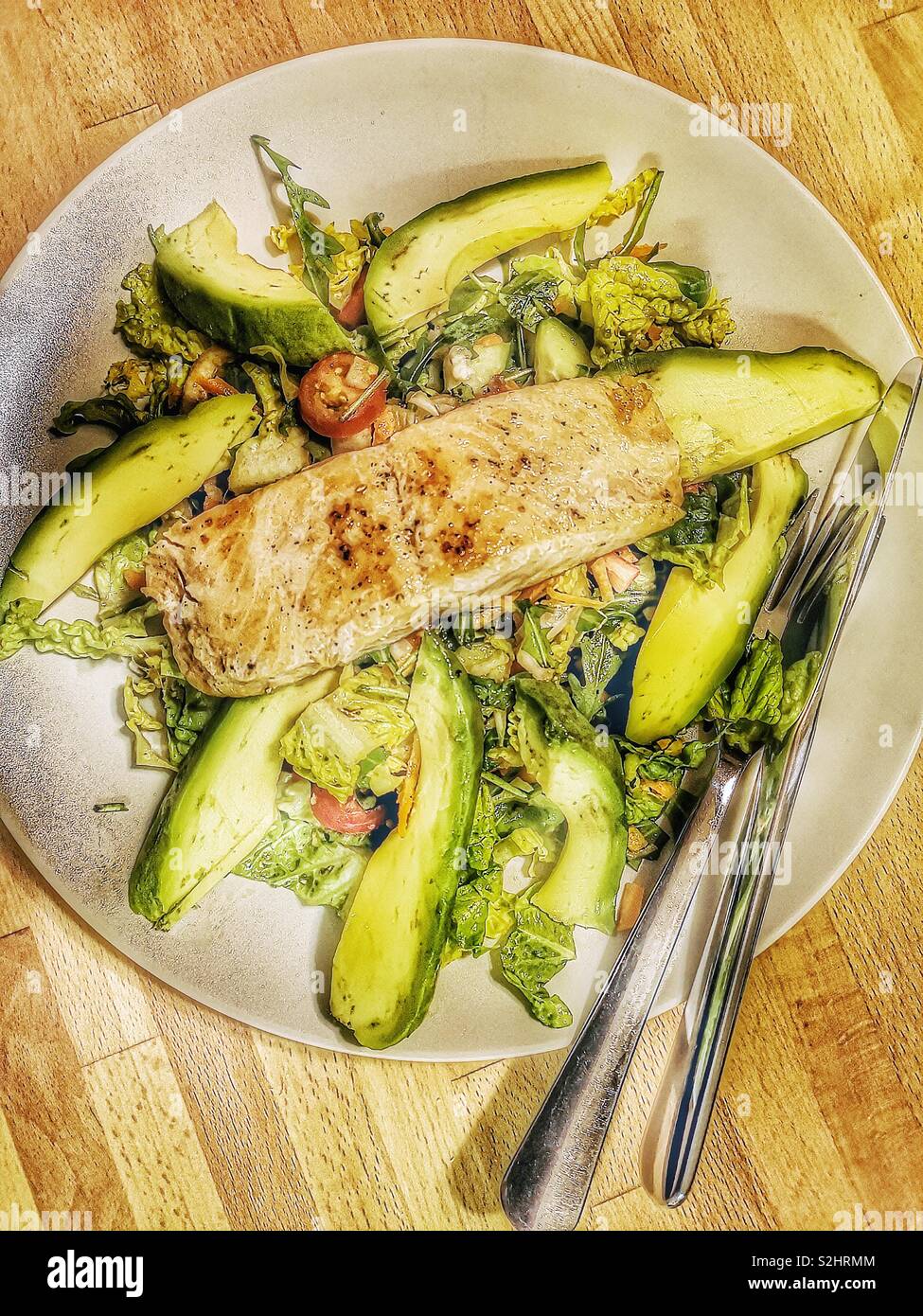 Fresh avocado salad topped with grilled salmon steak - Smartphone Captured Stock Image