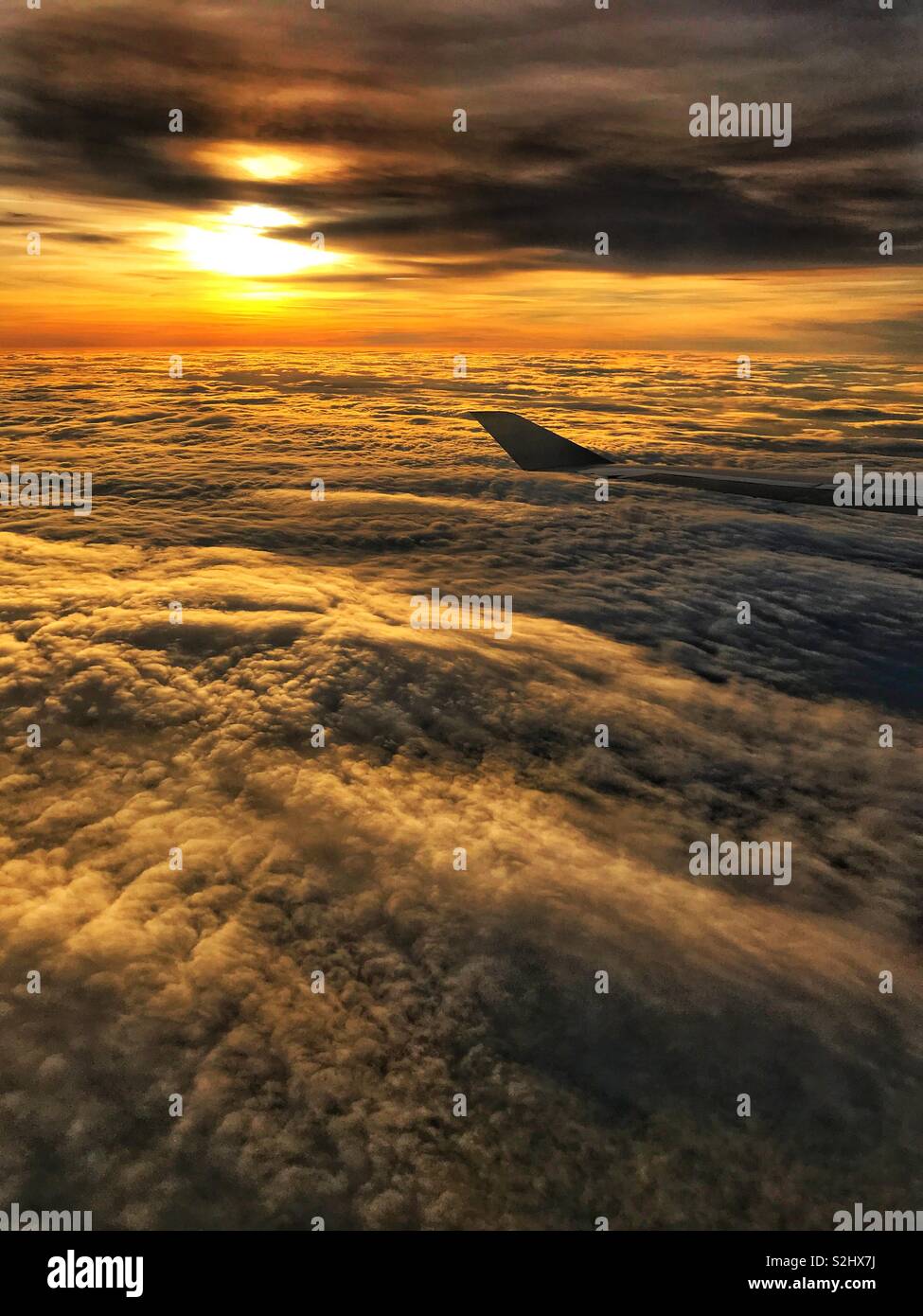 In flight above the clouds with a low evening sun - Smartphone Captured Stock Image