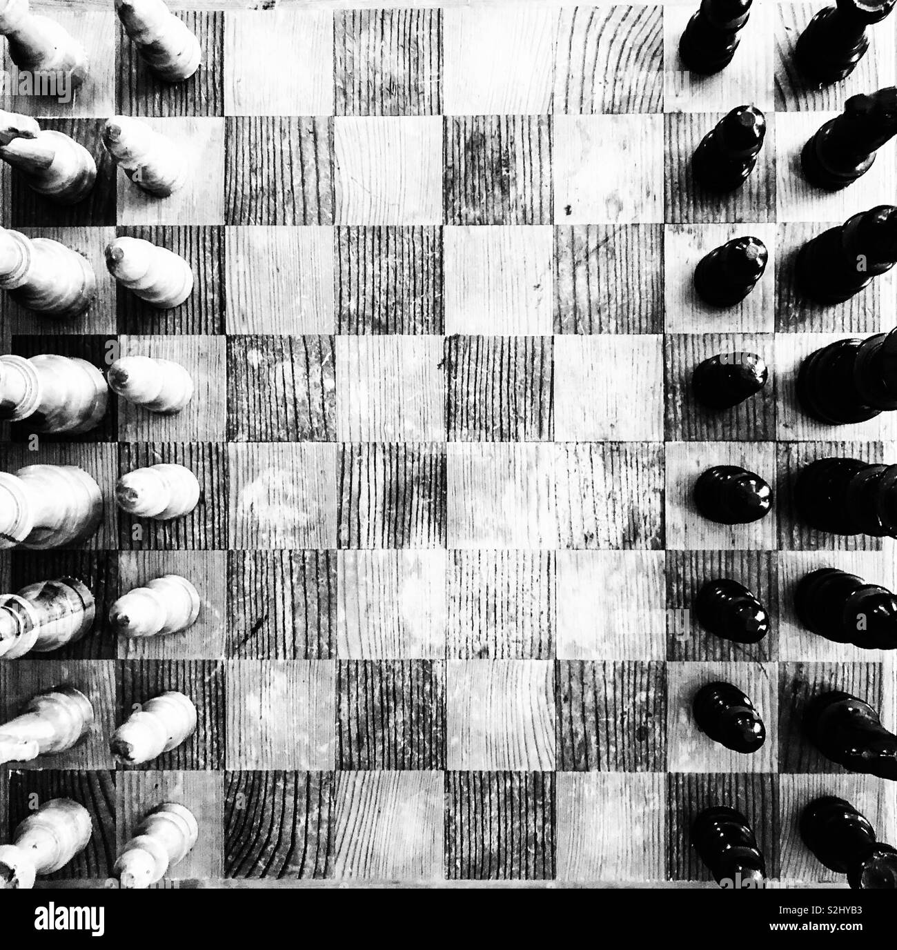 Old, rustic wooden chess board game from above view in black and white - Smartphone Captured Stock Image