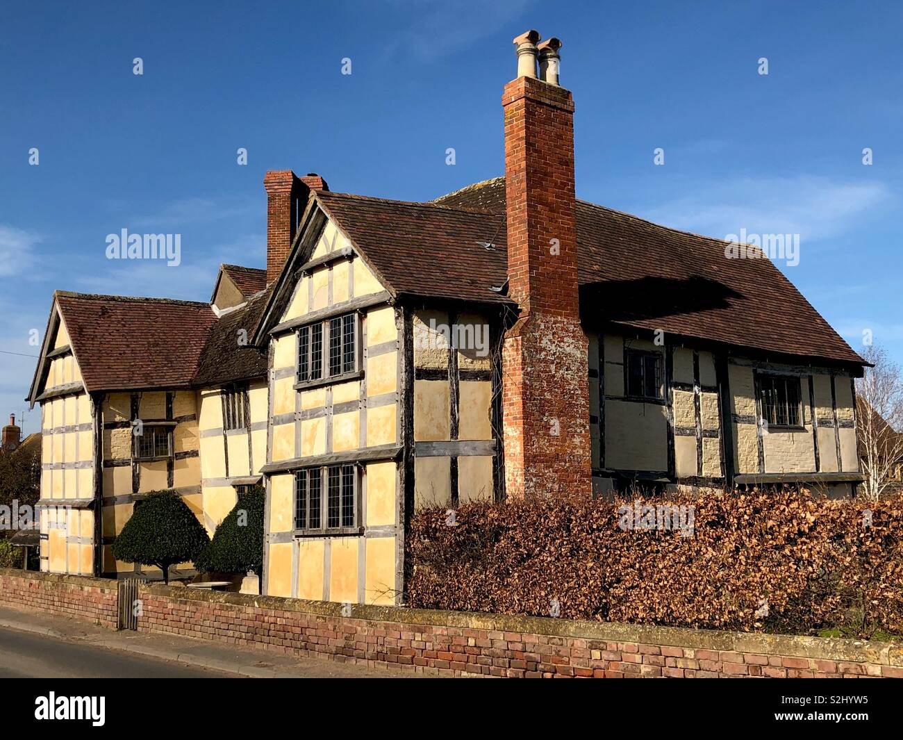 Beautiful medieval half-timbered crooked Manor House, near Tewkesbury coloured with pink ochre. - Smartphone Captured Stock Image