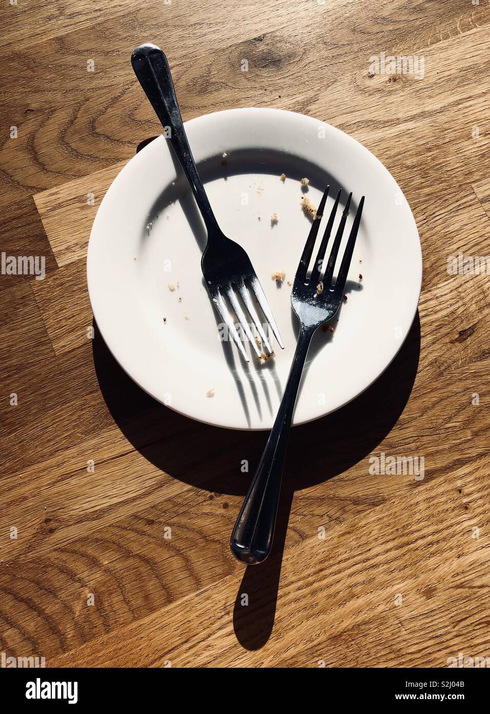 Two forks on an empty plate Stock Photo