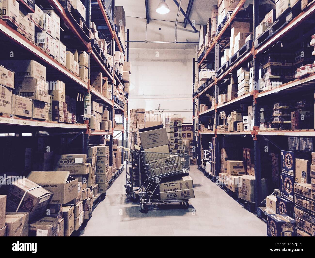A warehouse with shelves stacked with cardboard boxes. - Smartphone Captured Stock Image