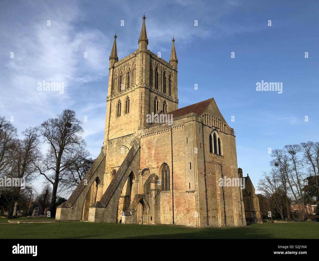 Pershore Abbey on a sunny spring afternoon with brilliant blue skies contrasting with honey coloured stone. - Smartphone Captured Stock Image