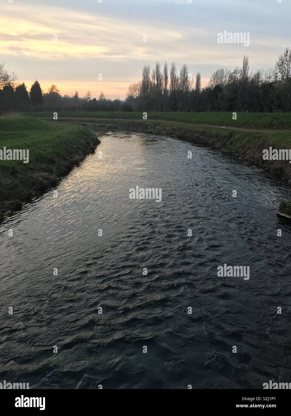 The River Mersey flowing through Didsbury near Simon’s Bridge, towards Northenden as the sun is setting Stock Photo
