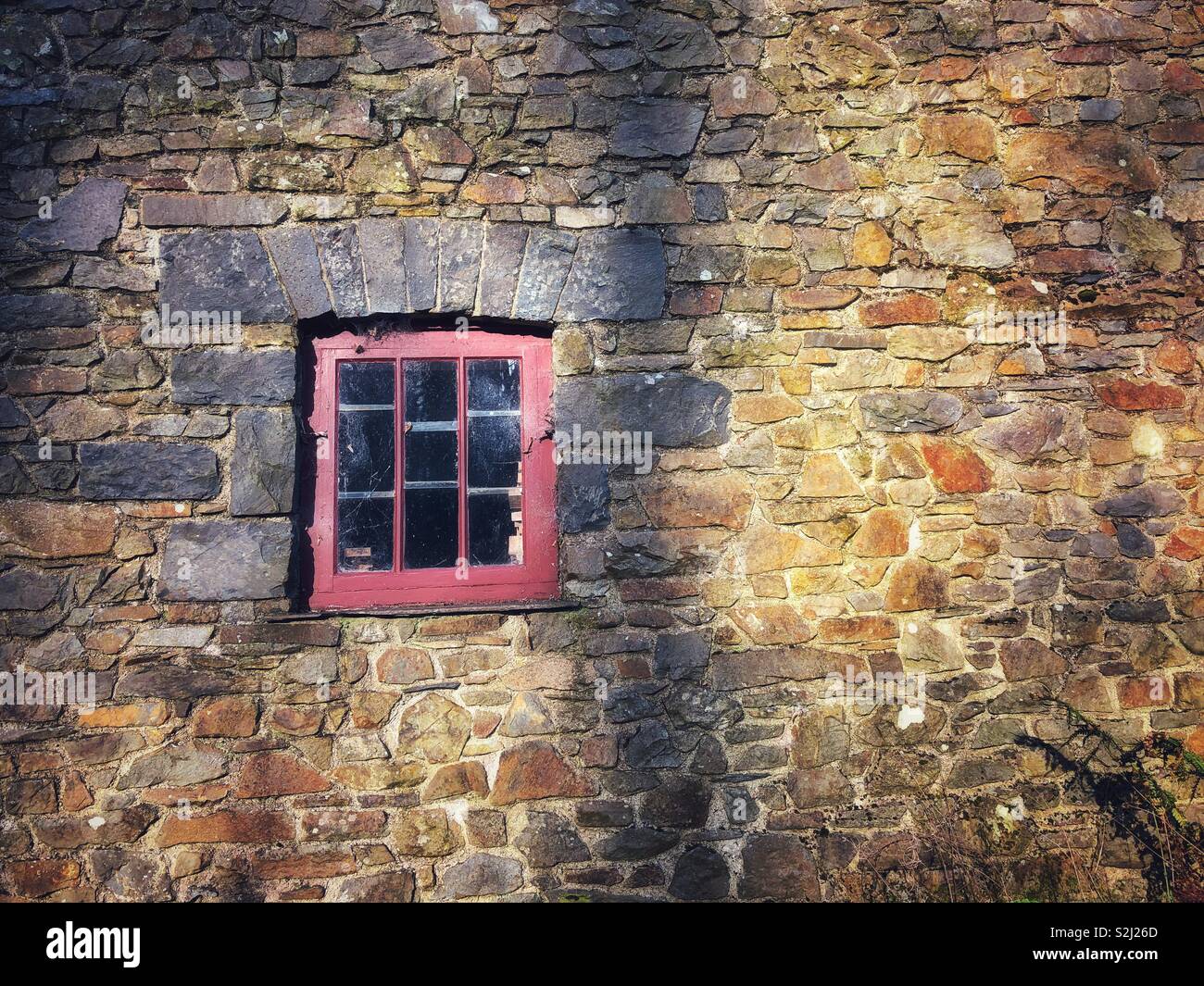 Window in a stone wall at St Fagans Museum of Welsh Life. - Smartphone Captured Stock Image