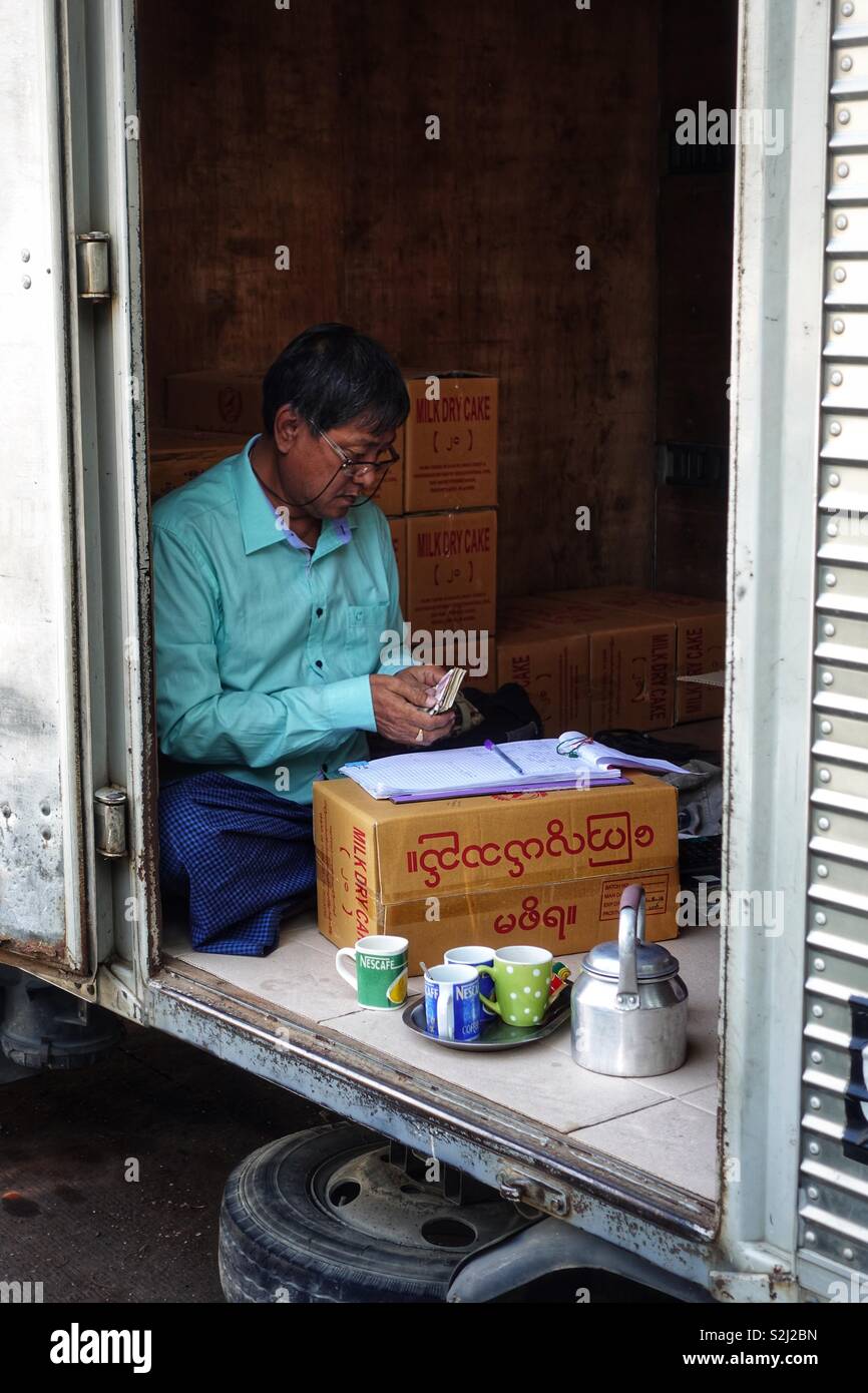 A single burmese man doing business in his truck. With open door. Stock Photo