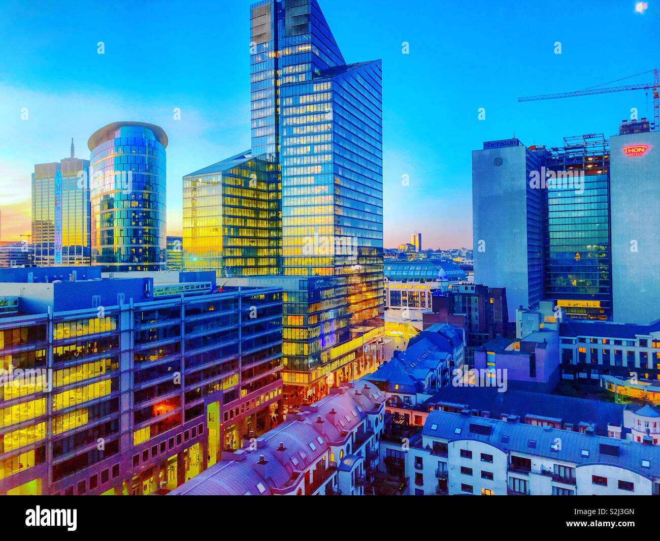 A full spectrum of colors during sunrise shown in the sky and the reflection of the sky in the glass of the business offices of the financial district of the city - Smartphone Captured Stock Image