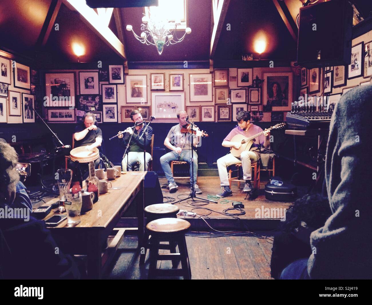 Irish musicians in a pub playing traditional Irish music to the people watching at tables in Cork Ireland - Smartphone Captured Stock Image