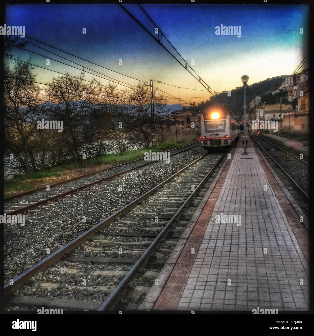 The “Catalunya Express” enters the station in Ascó at dusk, Catalonia,  Spain Stock Photo - Alamy