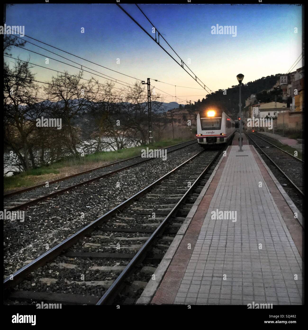 The “Catalunya Express” enters the station in Ascó at dusk, Catalonia, Spain. - Smartphone Captured Stock Image