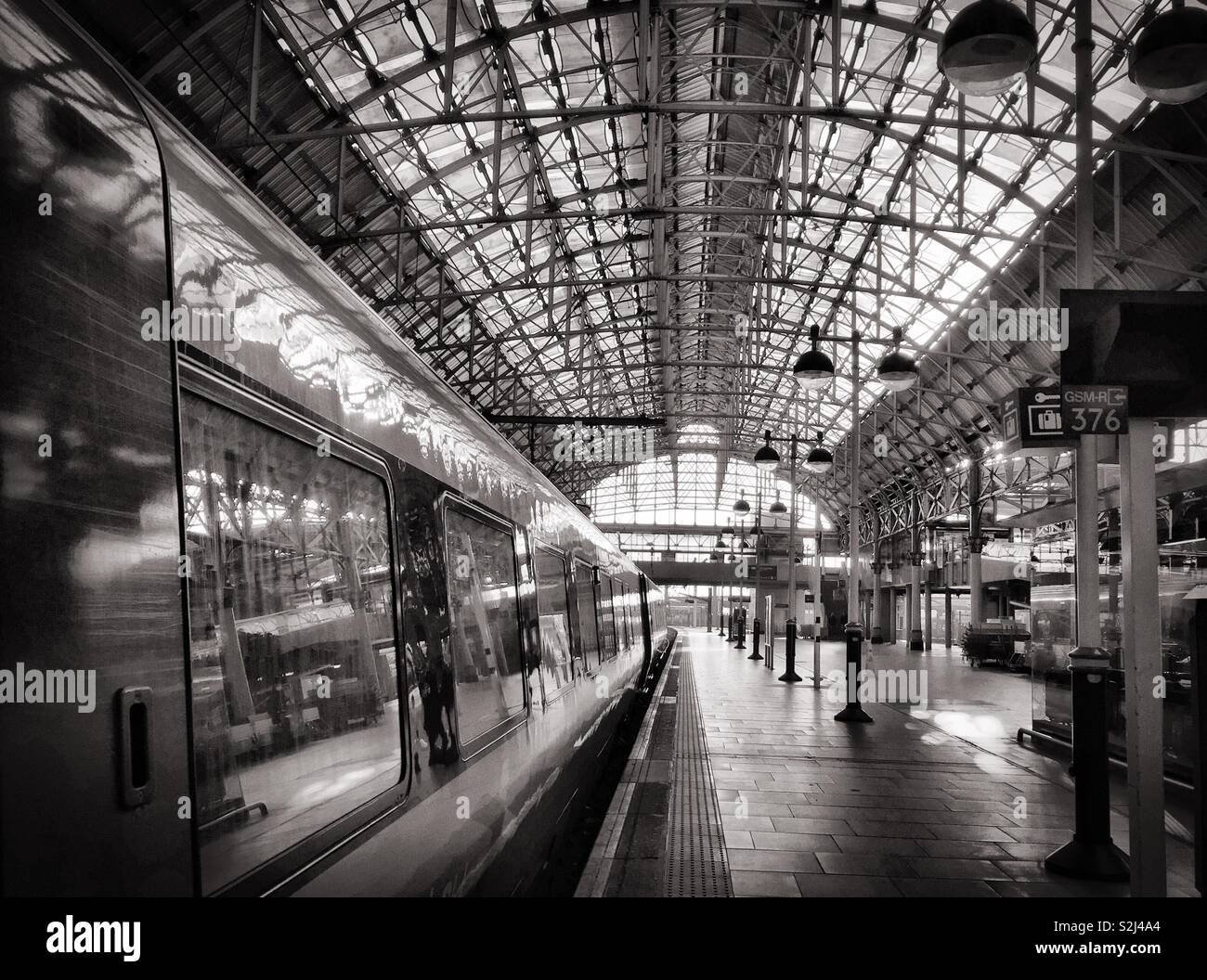 Railway train platform.  Train arriving/departing at station.  This photo is shot at Manchester Piccadilly. - Smartphone Captured Stock Image