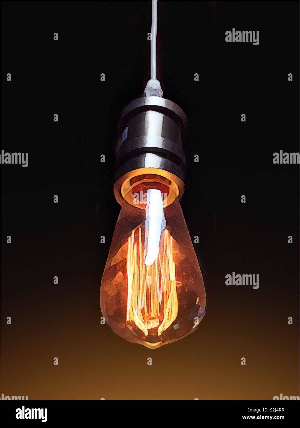 Lightbulb graphic with warm radiant glow and black background - Smartphone Captured Stock Image