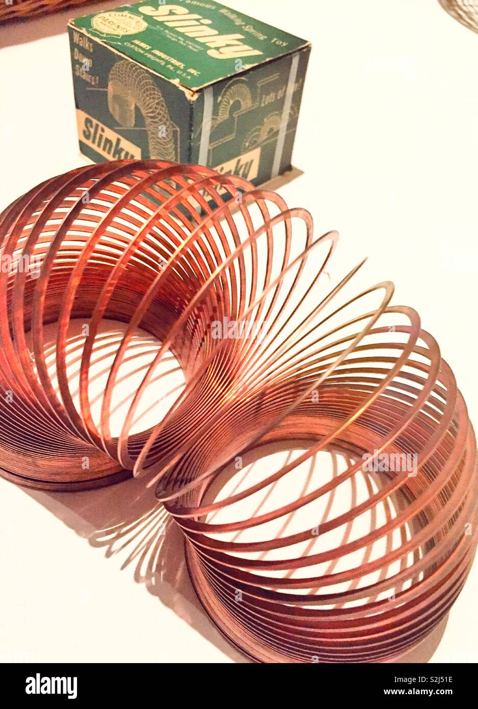 Slinky toy next to its original box from the 50s, USA Stock Photo