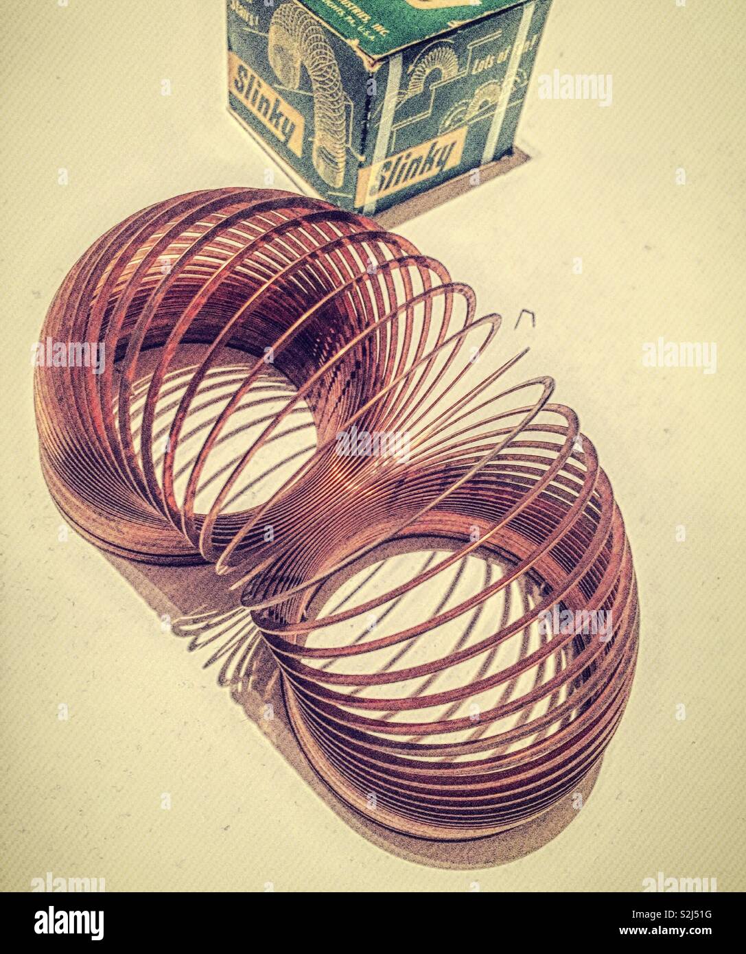 Slinky toy next to its original package from the 1950s, USA Stock Photo
