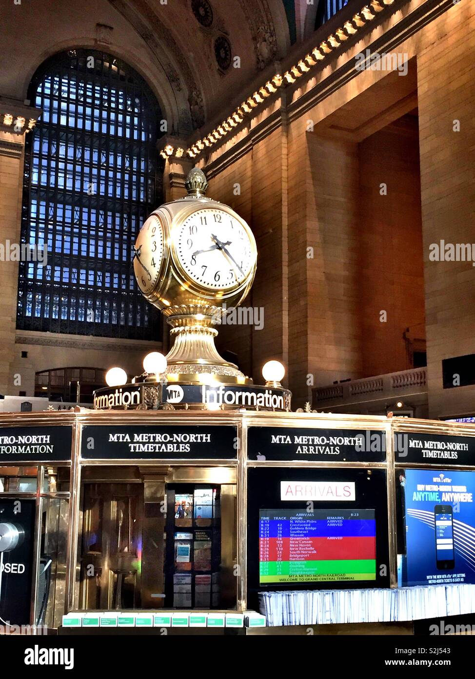 The massive clock above the information kiosk in the grand concourse of Grand Central Terminal is four sided, NYC, USA Stock Photo