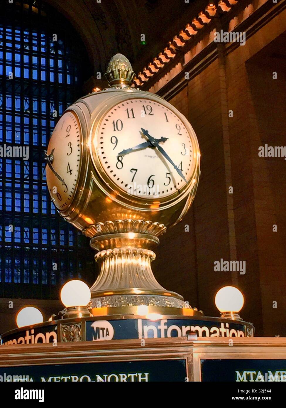 The massive clock above the information kiosk in the grand concourse of Grand Central terminal is four sided, New York City, USA Stock Photo