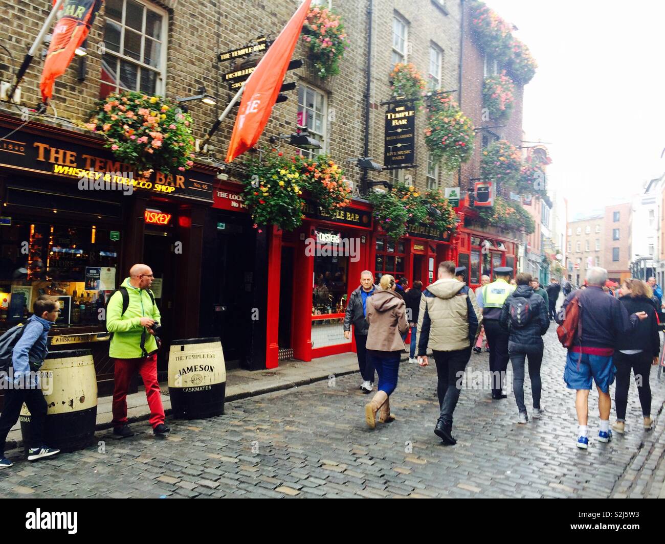 Temple Bar pub in Temple Bar district in the city of Dublin on a cobbled lane busy with people during a cold Autumn day in Ireland - Smartphone Captured Stock Image