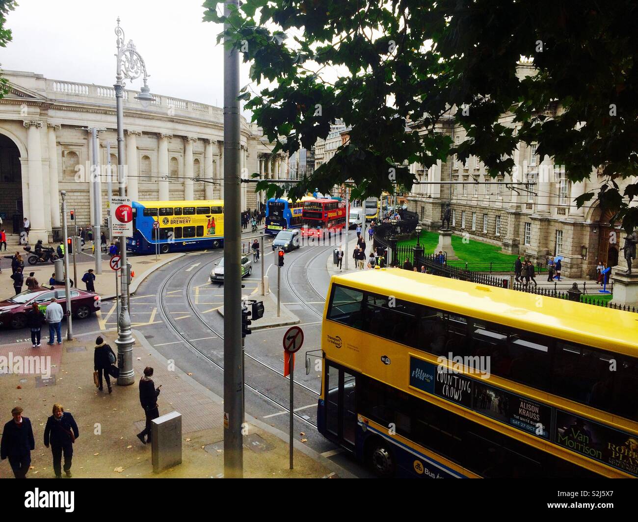 Looking down onto a busy street or road in Dublin city centre with busses and people or pedestrians on pavements concept travel and tourism - Smartphone Captured Stock Image