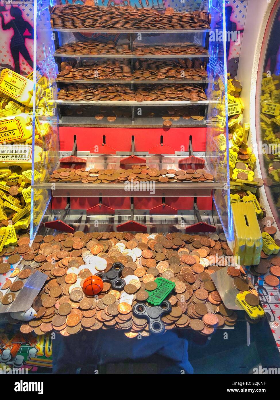 Penny falls machine in a seaside amusement arcade. Stock Photo