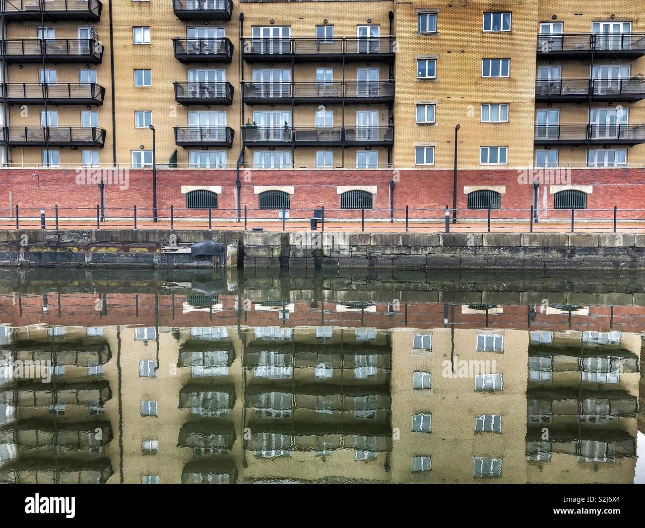 Waterside apartments reflected in the dock at Cardiff Bay, South Wales. - Smartphone Captured Stock Image