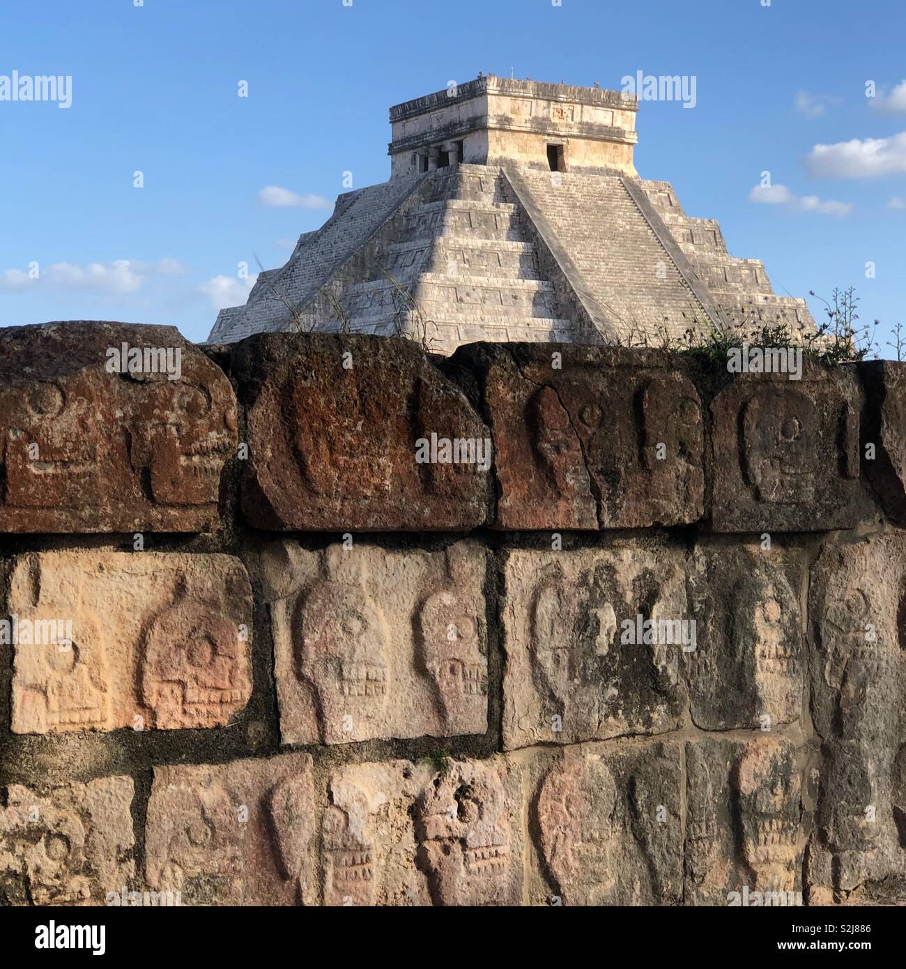 Magnificent architecture of El Castillo or Temple of Kukulcan and the wall of sculls in Chichen Itza, yucatan, mexico - Smartphone Captured Stock Image