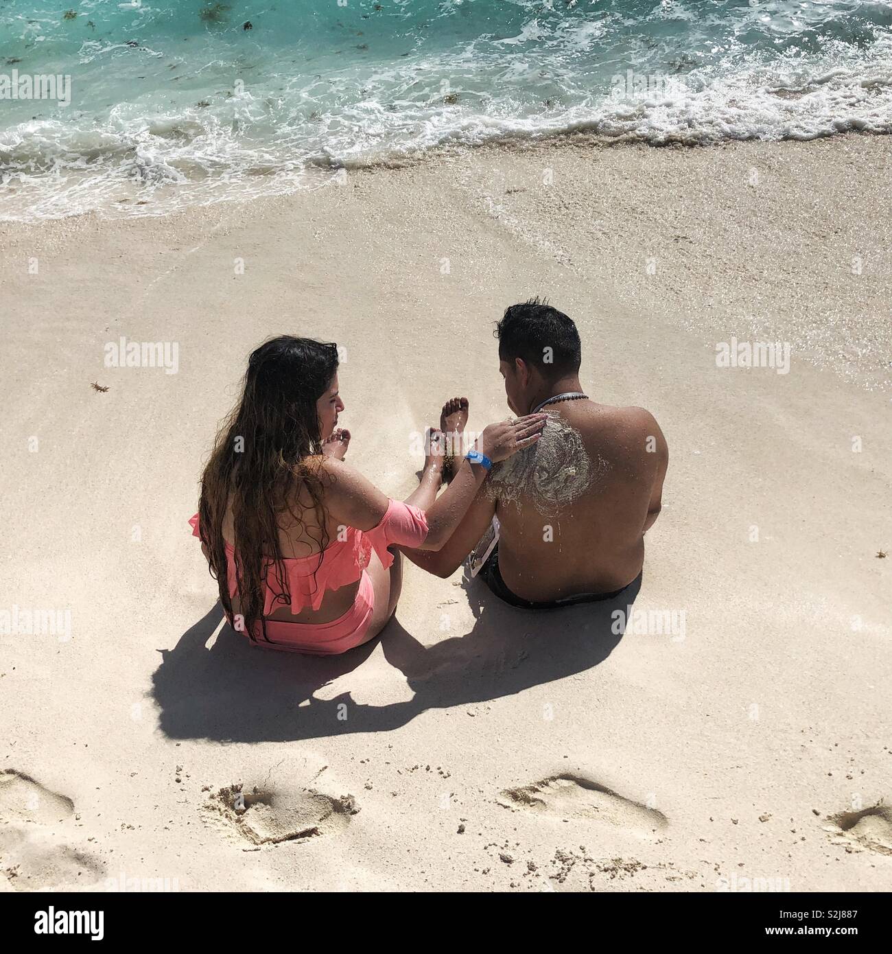 Couple sitting on a sandy beach in Cancun, Mexico - Smartphone Captured Stock Image