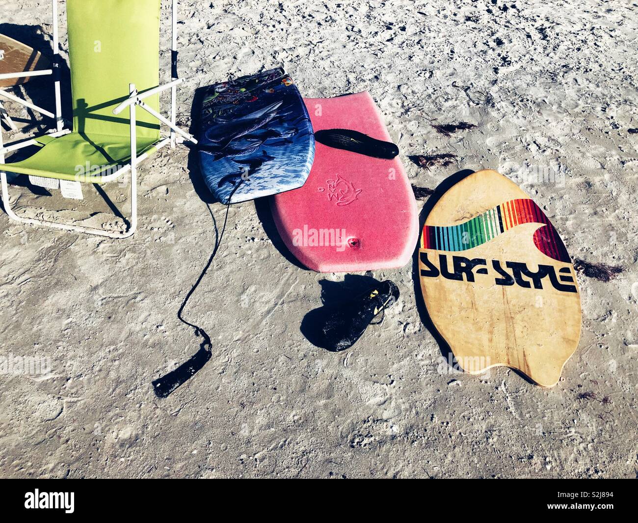 Boogie boards left on white sand of Clearwater Beach, Florida - Smartphone Captured Stock Image