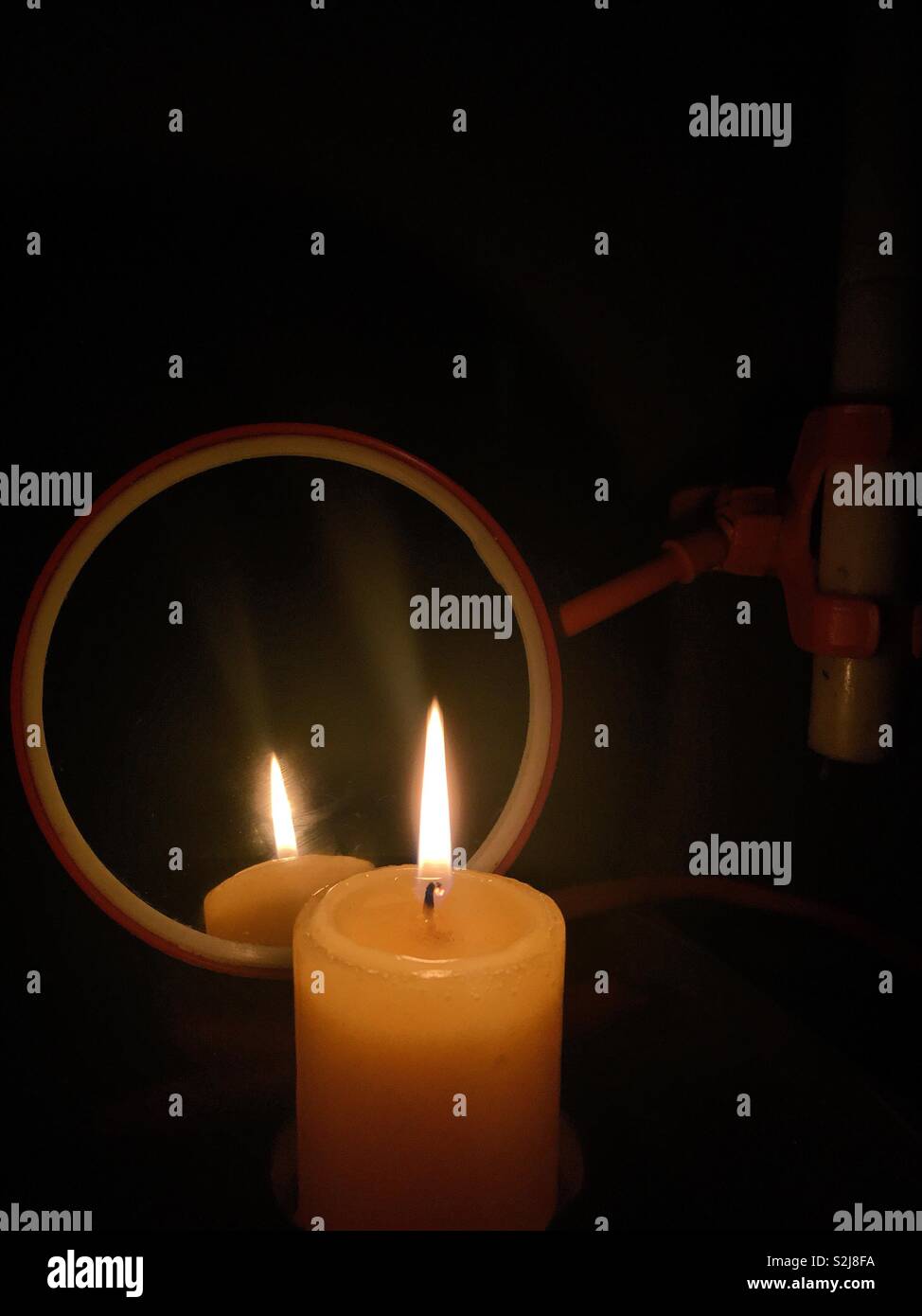 A single candle lights up the room during storm. - Smartphone Captured Stock Image