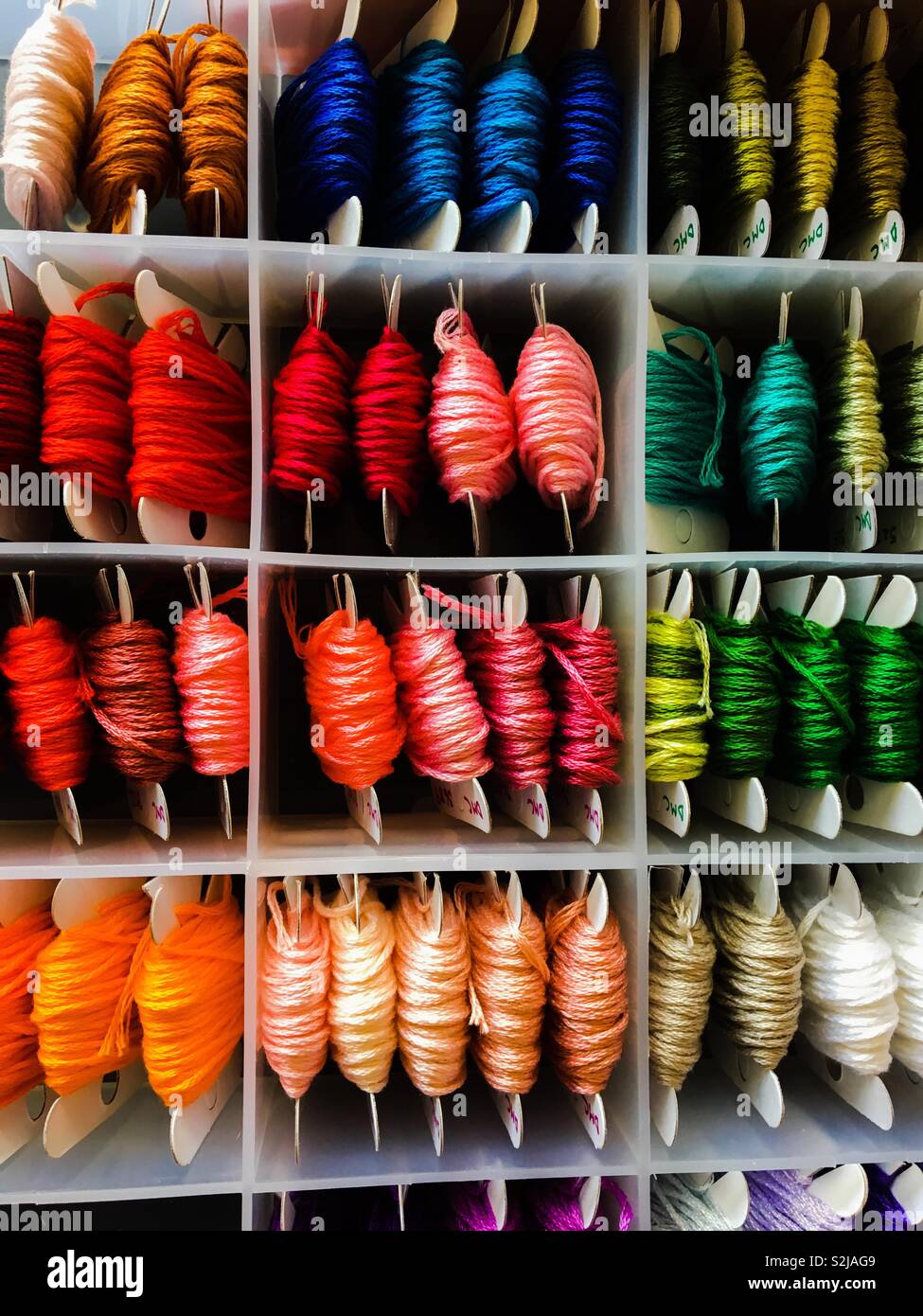 multi Coloured reels of embroidery threads in a storage box partitions - Smartphone Captured Stock Image