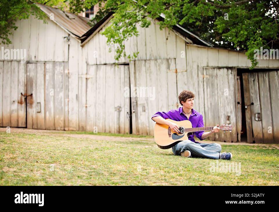 Playing guitar in a field Stock Photo