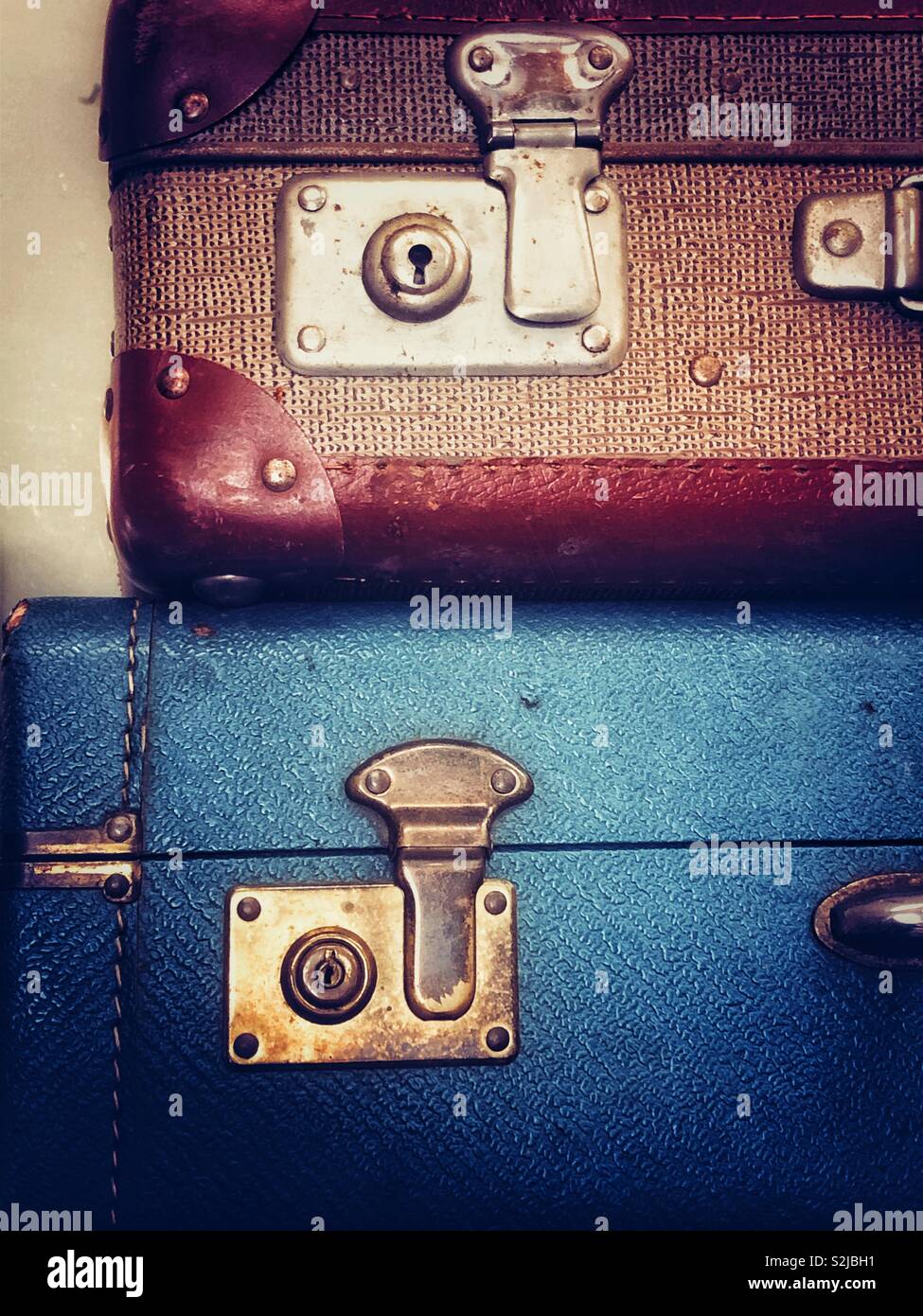 Vintage brown and blue suitcases stacked for sale in an antique shop - Smartphone Captured Stock Image