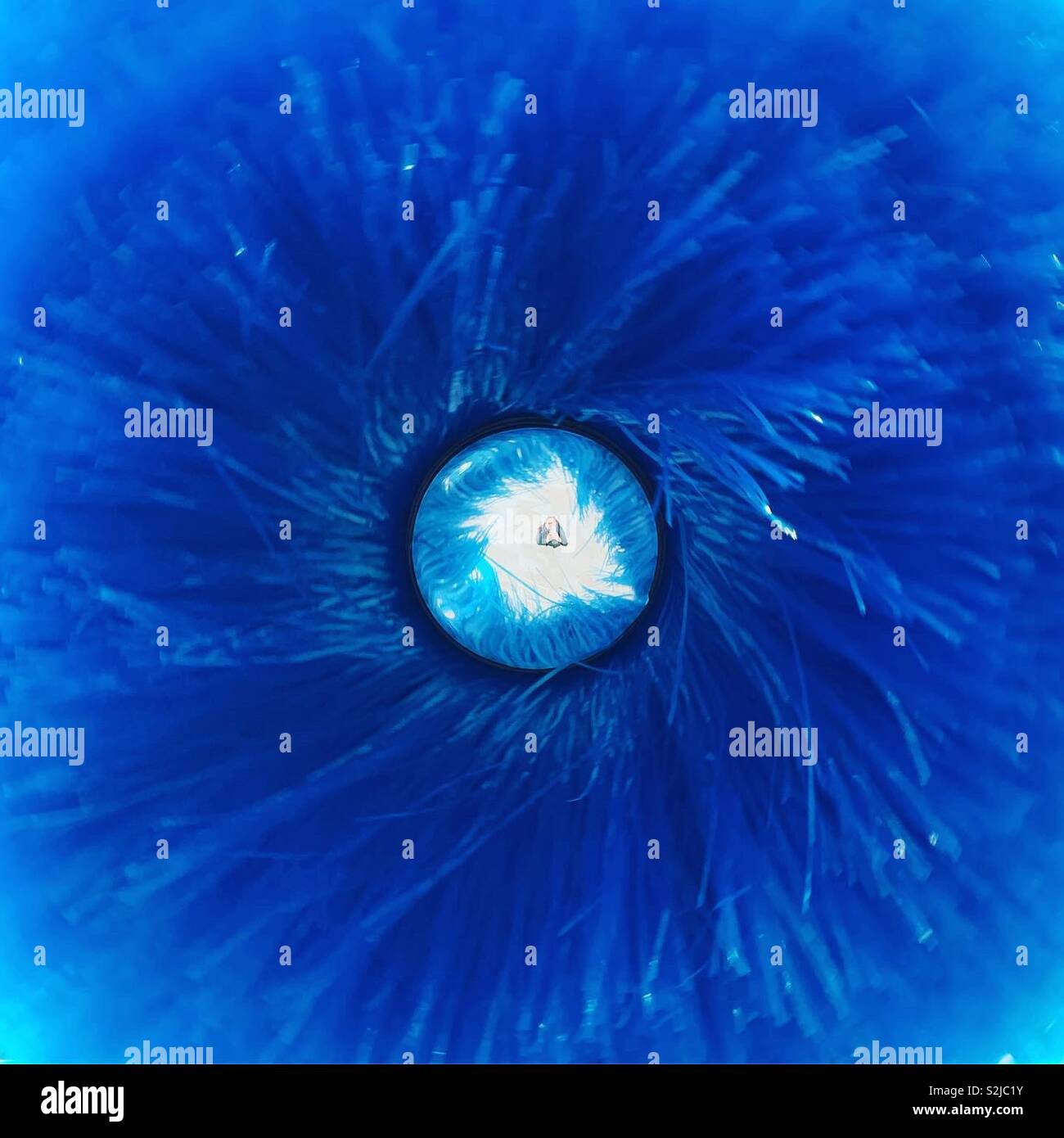 Woman taking a selfie under a blue blow-driven rotating object. M9 Area, Mestre, Italy. - Smartphone Captured Stock Image