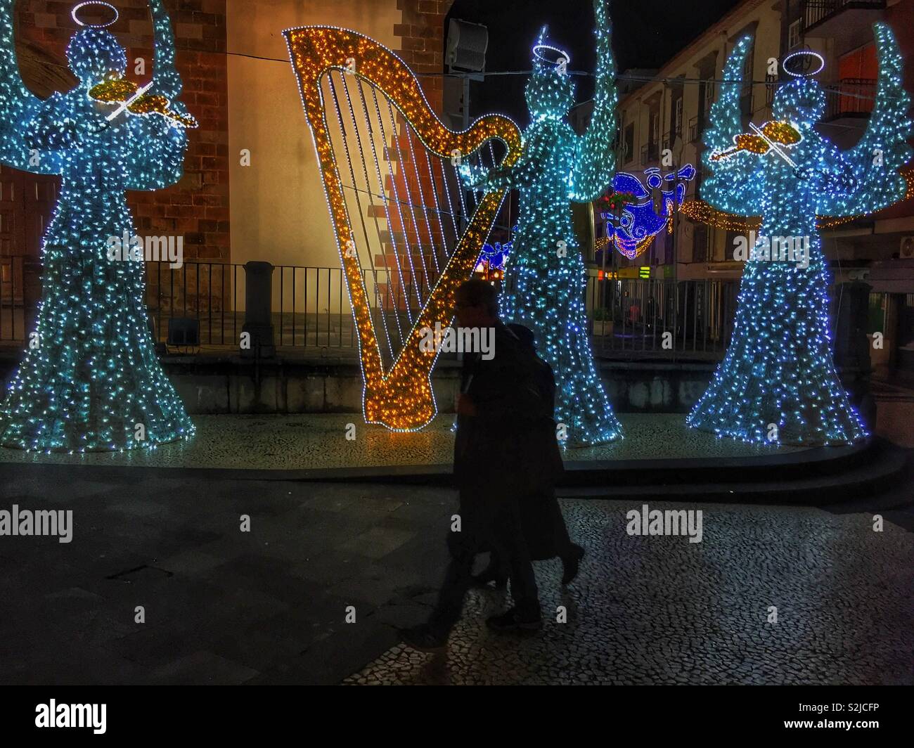 Christmas lighting on three angels playing musical instruments. Stock Photo