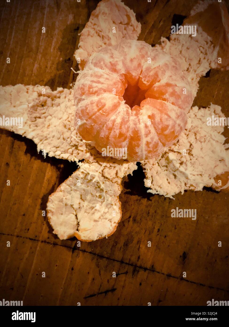 Whole tangerine sits on star shaped peeling - Smartphone Captured Stock Image