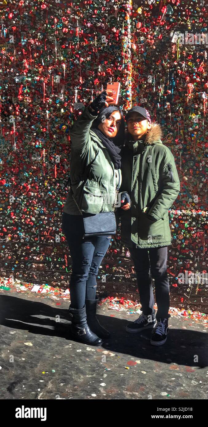Girls taking a selfie in front of the gum wall in Pike Place market, Seattle Washington Stock Photo