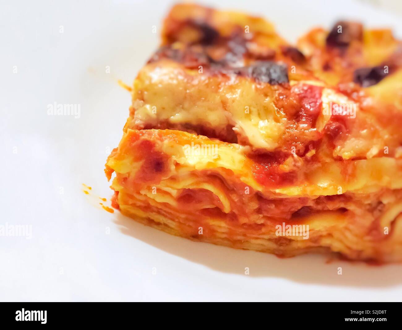 close-up view of a portion of Italian lasagna served in a white plate - Smartphone Captured Stock Image