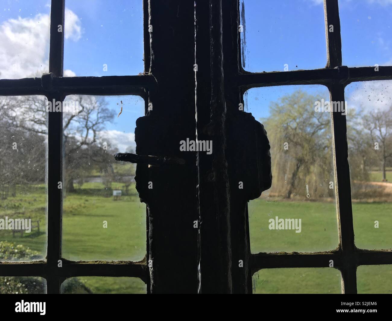 Garden view through an old black metal window - Smartphone Captured Stock Image